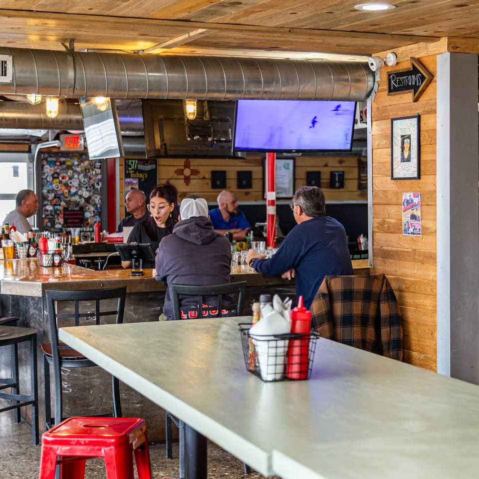 Patrons enjoying drinks and conversation at the bar inside The 377 Brewery.
