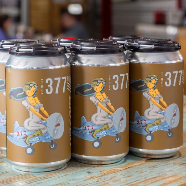 The 377 Brewery beer cans with a pin-up girl riding a plane on the label.